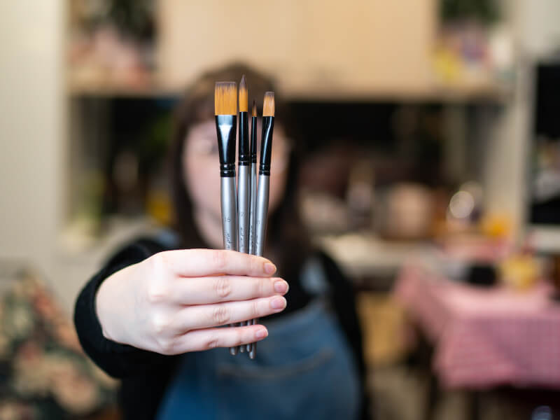 woman holding paintbrushes